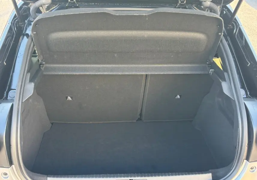 Coffre ouvert vu de dessus d'une Lancia Ypsilon gris 2025, montrant l'espace de rangement et la tablette arrière.