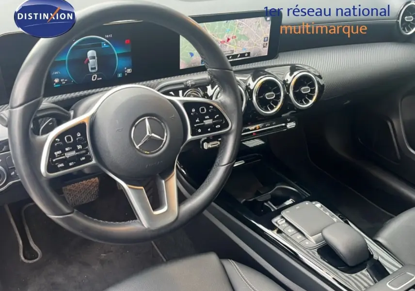 Intérieur noir de la Mercedes Classe A 180 Business Line 2020, vue sur le volant et la console centrale moderne avec écran tactile.