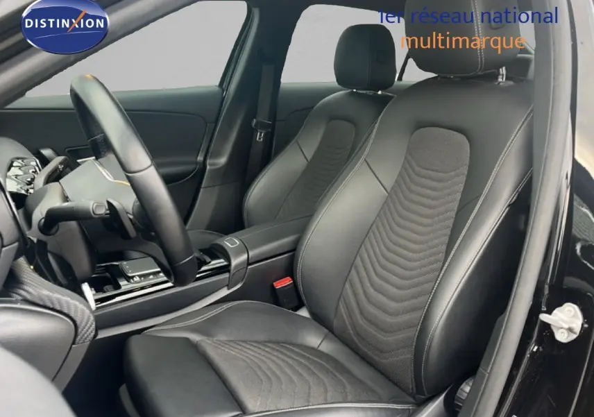 Vue intérieure côté conducteur de la Mercedes Classe A 180 Business Line 2020 avec sièges cuir noir et volant multifonction.