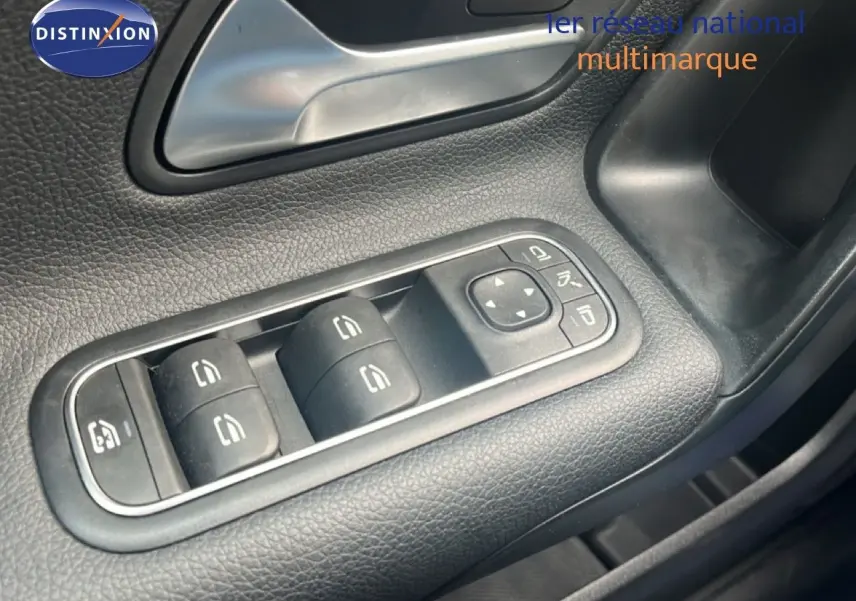 Gros plan sur les commandes des vitres côté conducteur d'une Mercedes Classe A 180 Business Line noire cosmos métal.