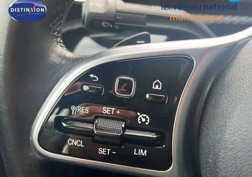 Gros plan sur les commandes de régulateur de vitesse au volant cuir noir d'une Mercedes Classe A 180 Business Line 2020.