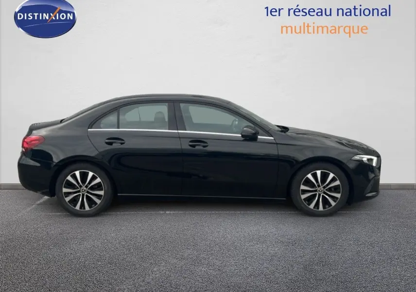 Profil côté gauche d'une Mercedes Classe A 180 Business Line noire Cosmos Metal, avec jantes alliage bicolores.