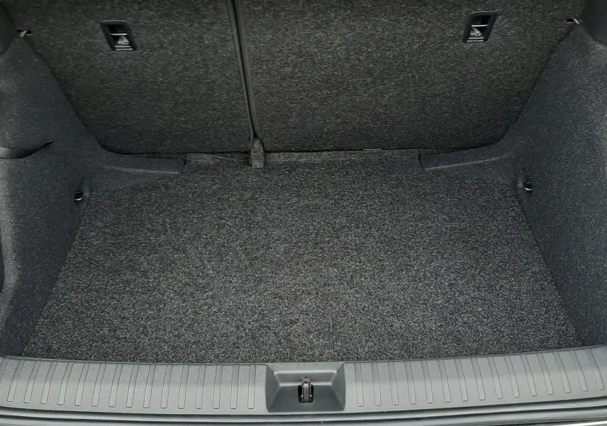 Coffre ouvert vu de face d'un Skoda Kamiq gris graphite métal 2025, intérieur en tissu gris foncé.