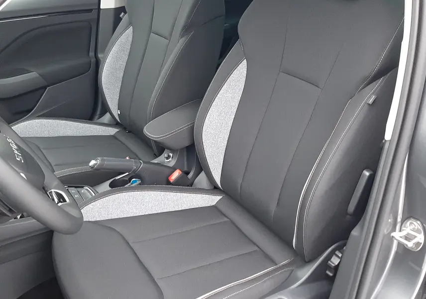 Vue rapprochée des sièges avant noirs et gris du Skoda Kamiq 2025, version 1.0 TSI, avec portière ouverte côté conducteur.