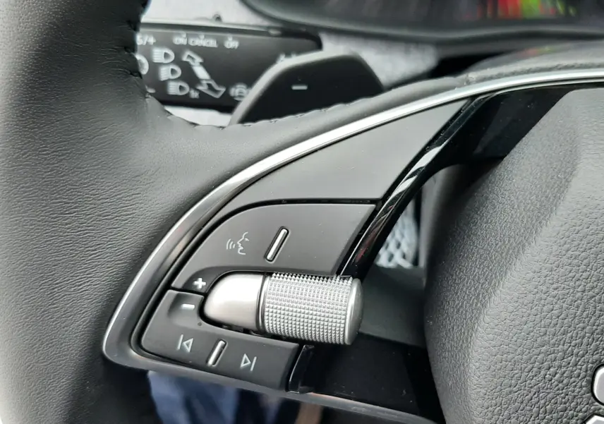 Gros plan sur les commandes gauche du volant noir du Skoda Kamiq gris graphite, avec molette et boutons multifonctions.
