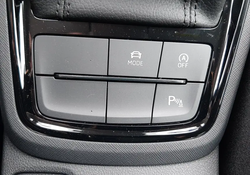 Gros plan sur les boutons de commande noirs de la console centrale du Skoda Kamiq 2025, finition tissu noir gris.