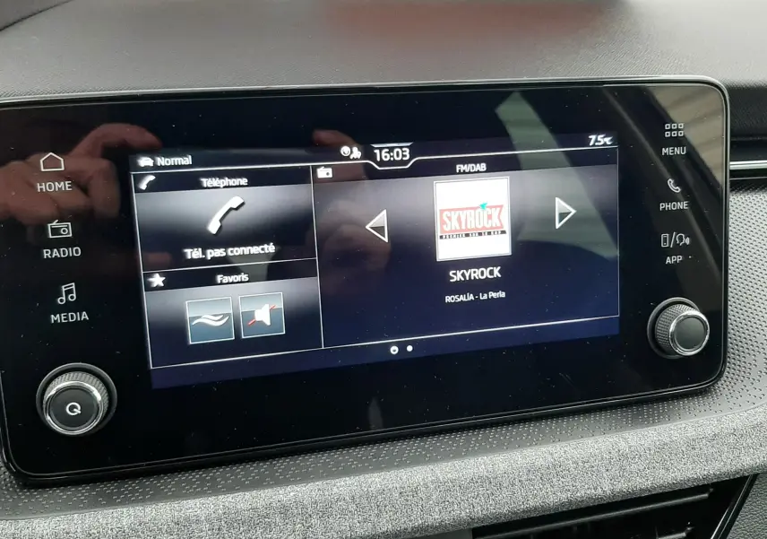 Écran tactile central du Skoda Kamiq 2025 affichant la radio Skyrock, avec commandes et boutons autour.