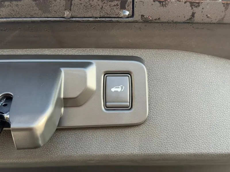 Bouton d'ouverture électrique du coffre sur la porte arrière intérieure du Renault Scenic E-Tech blanc 2025.