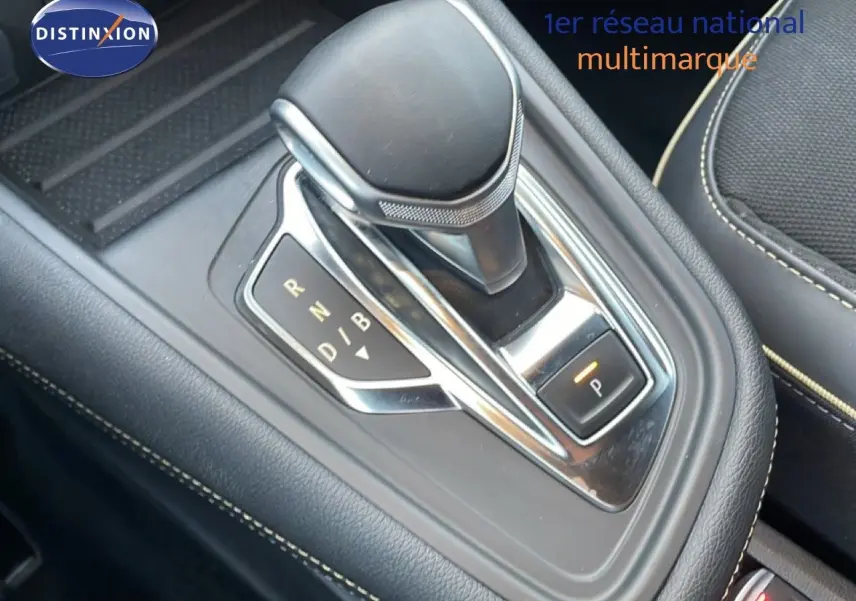 Gros plan sur le levier de vitesse automatique noir et chrome de la Renault Symbioz 2025, intérieur cuir noir avec surpiqûres beiges.