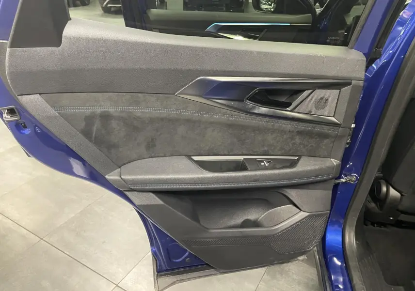 Vue intérieure côté gauche de la porte arrière bleu Iron du Renault Austral 2024 avec garniture Alcantara et surpiqûres bleues.