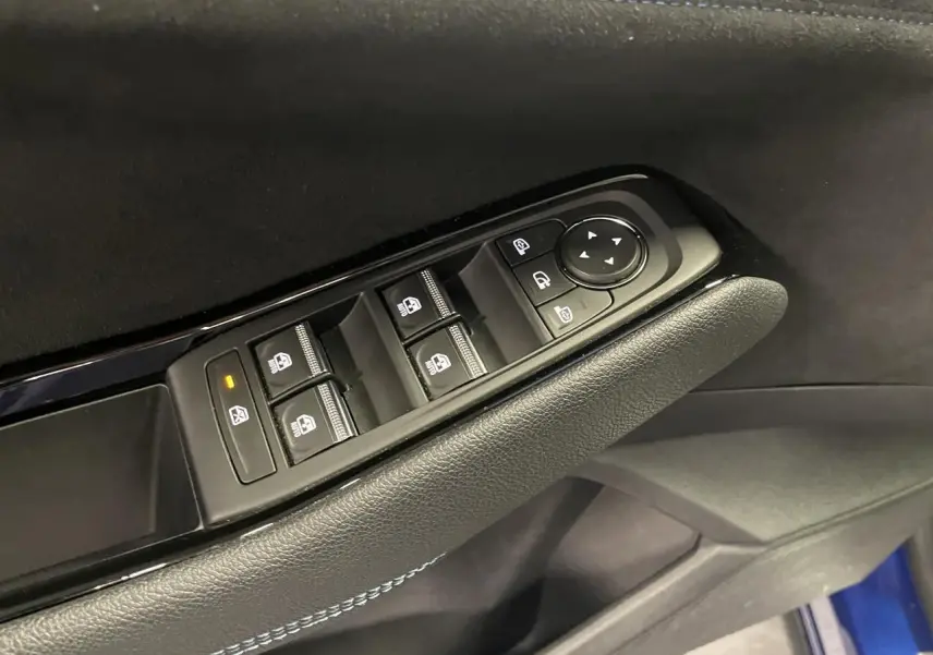 Détail de la commande des vitres électriques sur la porte côté gauche d’un Renault Austral 2024 Bleu Iron.
