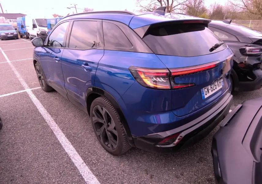 Vue 3/4 arrière gauche du Renault Austral 2024 bleu Iron avec jantes noires et vitres teintées.