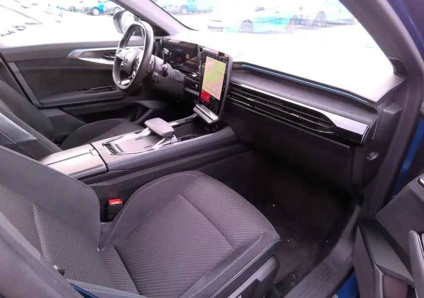 Vue intérieure côté conducteur du Renault Austral 2024 bleu, avec sellerie mixte tissu-Alcantara et écran tactile vertical.