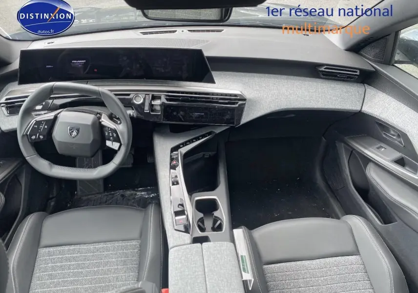 Vue intérieure avant du Peugeot 5008 Hybrid 145 allure e-dcs6 2025, tableau de bord et volant cuir noir avec inserts gris.
