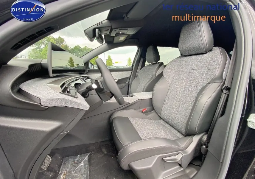 Vue intérieure côté conducteur du Peugeot 5008 Hybrid 145 allure e-dcs6 2025, sièges tissu gris et cuir noir.