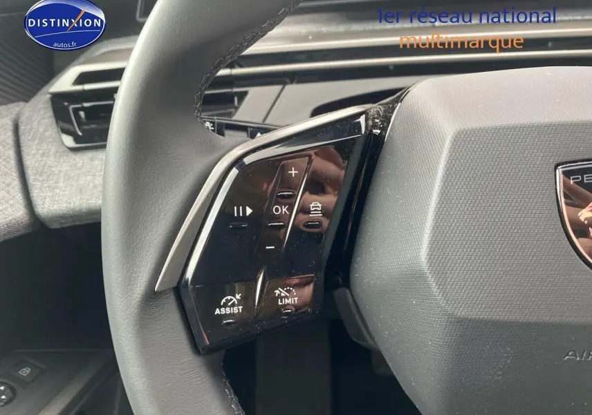 Gros plan sur le volant cuir noir du Peugeot 5008 Hybrid 145 allure 2025, avec commandes multifonctions visibles côté gauche.
