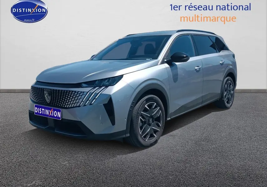 Peugeot 5008 gris artense en 3/4 avant droit, avec calandre distinctive et jantes alu modernes.