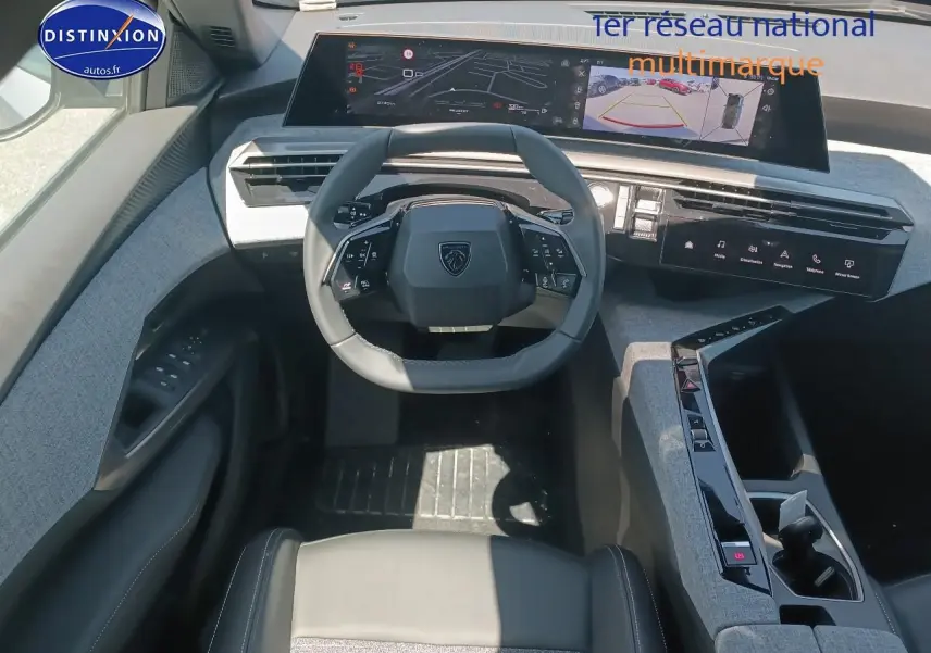 Vue intérieure frontale du poste de conduite du Peugeot 5008 Hybrid 145 allure e-dcs6 avec volant cuir et tableau de bord numérique.