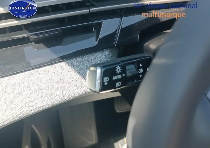 Détail intérieur du commutateur de phares sur le côté gauche du volant d’un Peugeot 5008 gris Artense 2025.