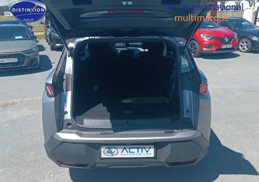 Vue arrière d’un Peugeot 5008 Hybrid 145 allure e-dcs6 gris artense avec coffre ouvert en extérieur.