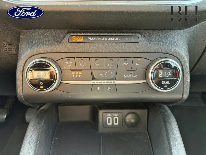 Vue rapprochée de la console centrale de la Ford Focus 1.0 Flexifuel 2021, montrant les commandes de climatisation et ports USB.