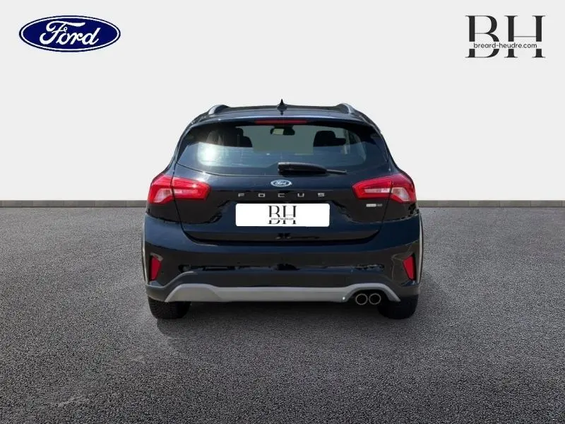 Vue arrière d'une Ford Focus noire Agate métallisé avec double sortie d'échappement et barres de toit visibles.