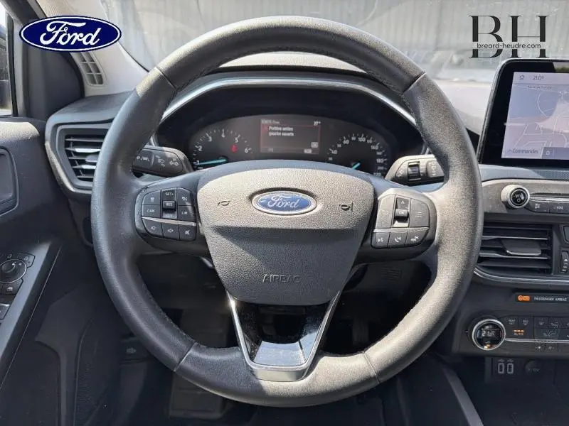 Vue rapprochée du volant cuir multifonction noir de la Ford Focus 1.0 Flexifuel 2021 avec tableau de bord et écran tactile.