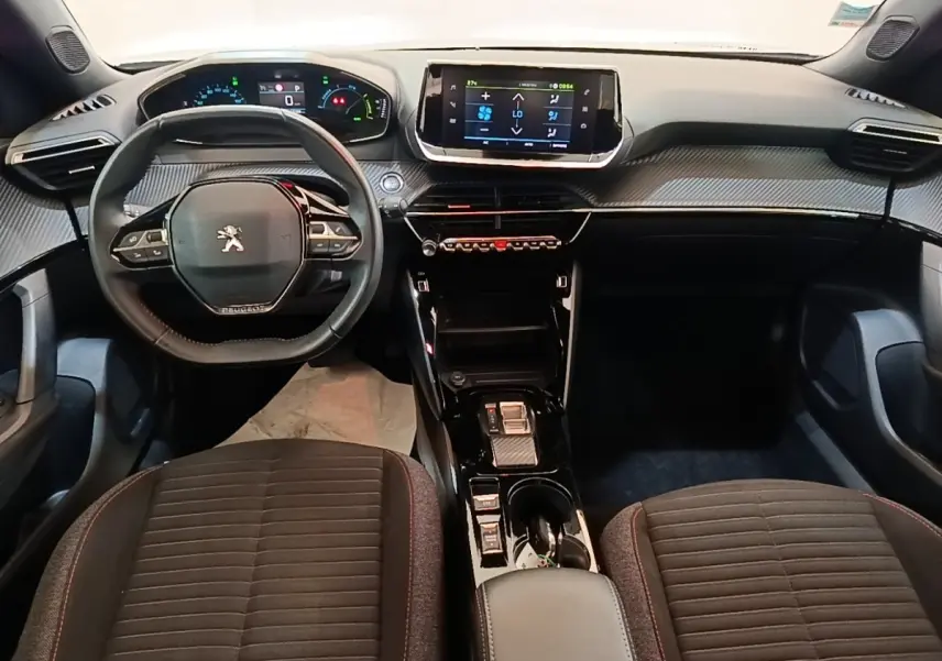 Vue intérieure avant du Peugeot E-2008 électrique 2023, volant cuir multifonctions et écran tactile central.