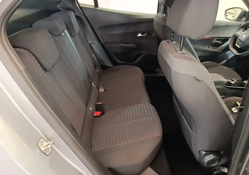 Vue intérieure côté gauche montrant la banquette arrière grise avec surpiqûres rouges du Peugeot E-2008 électrique 2023.