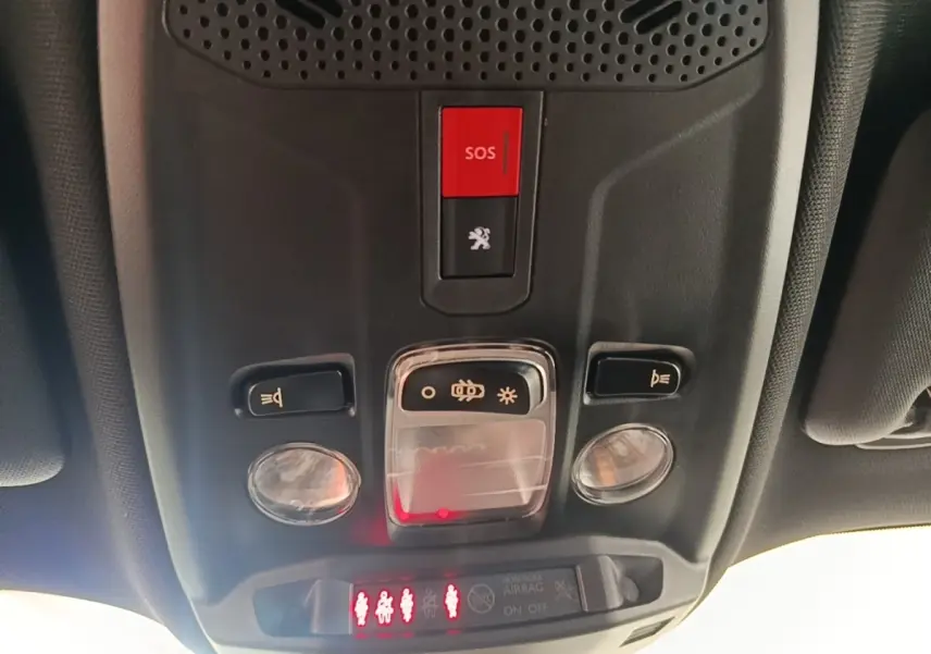 Plafonnier intérieur avec bouton SOS rouge et commandes d’éclairage dans un Peugeot E-2008 électrique gris clair 2023.