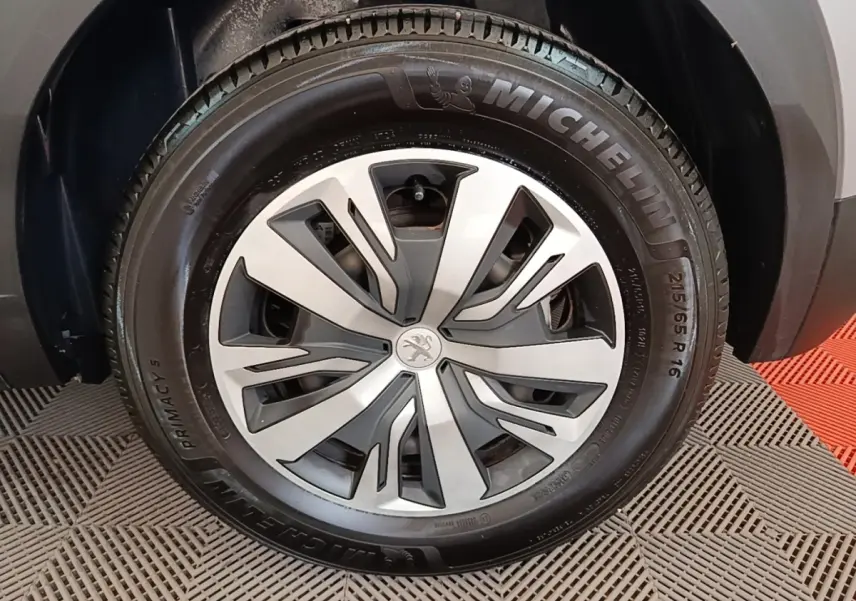 Gros plan sur la roue avant droite du Peugeot E-2008 électrique gris clair avec jante spécifique et pneu Michelin.