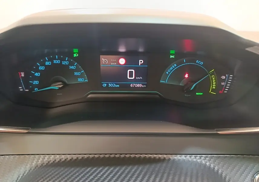 Vue rapprochée du tableau de bord numérique du Peugeot E-2008 électrique, affichant vitesse, autonomie et indicateurs de charge.