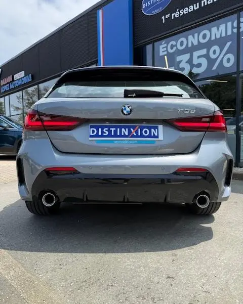 Vue arrière d'une BMW Série 1 118d gris foncé avec double sortie d'échappement et feux LED distinctifs.