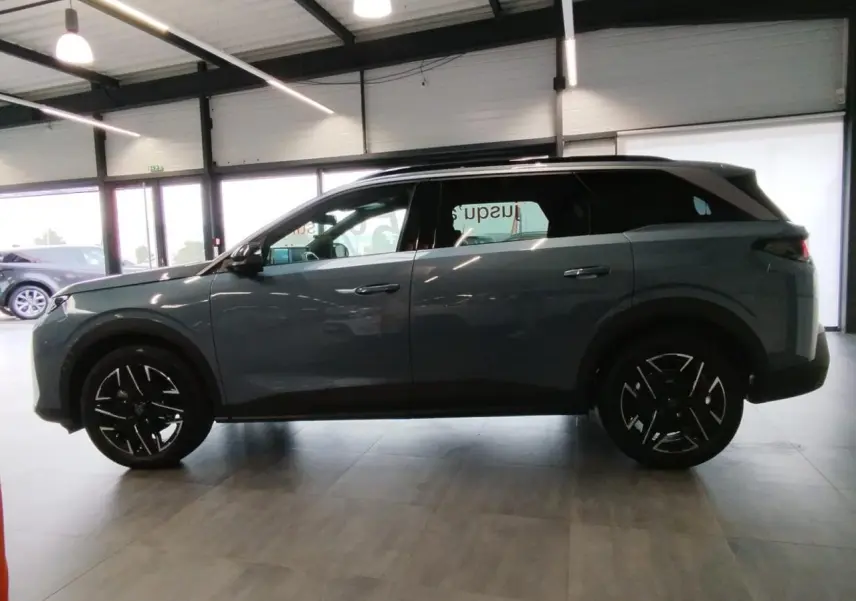 Profil côté gauche du Peugeot 5008 2025 bleu Ingaro avec jantes alliage noires et toit noir.