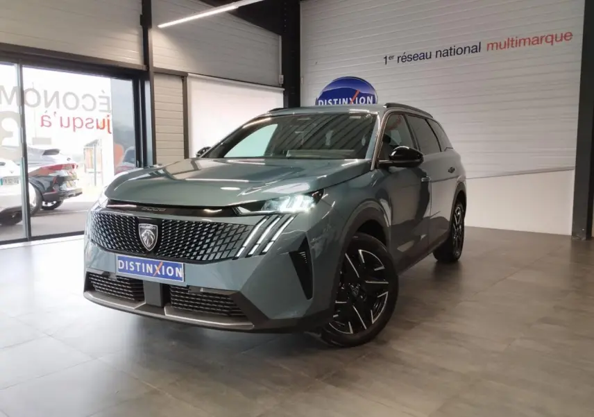 Peugeot 5008 bleu Ingaro vue 3/4 avant droit en intérieur avec calandre noire et jantes alliage noires.