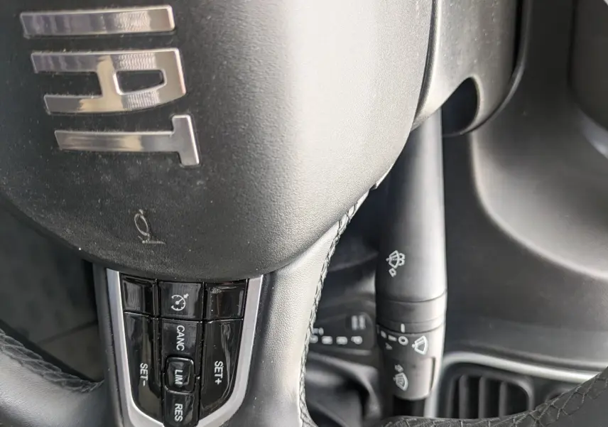 Gros plan sur le volant noir du Fiat Ducato Fourgon 2025 avec commandes intégrées et logo FIAT visible.
