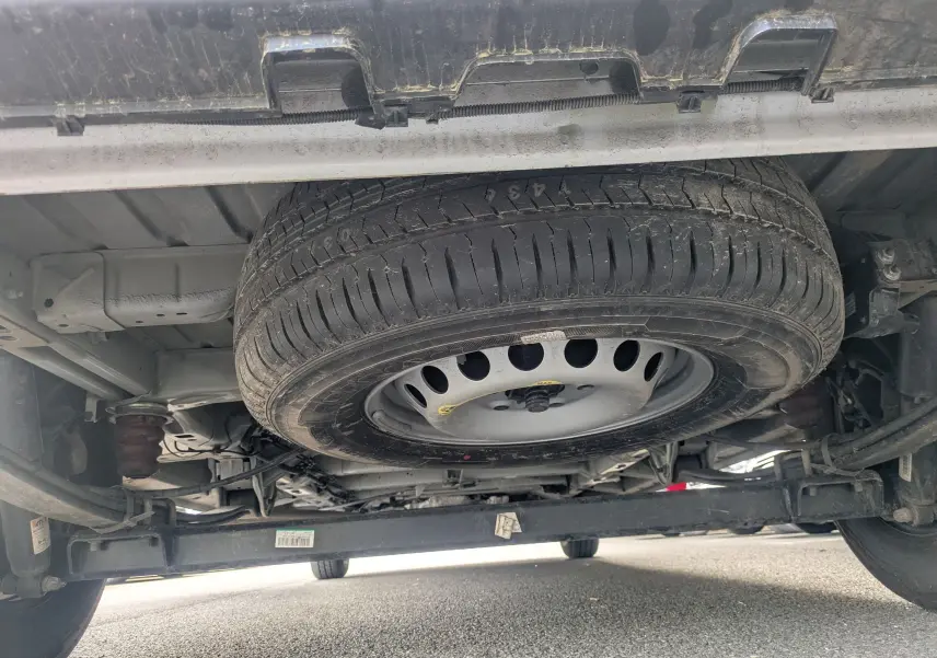 Vue en contre-plongée sous un FIAT Ducato Fourgon blanc, montrant la roue de secours fixée sous le châssis.