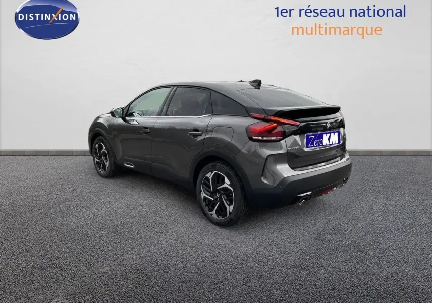Vue 3/4 arrière droite d'une Citroën C4 2024 gris platinium métal avec jantes bi-ton et feux LED distinctifs.