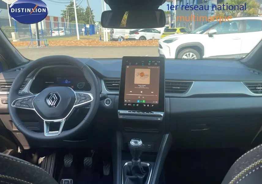 Intérieur de Renault Captur 2025 avec tableau de bord moderne, écran tactile vertical et volant multifonction noir.
