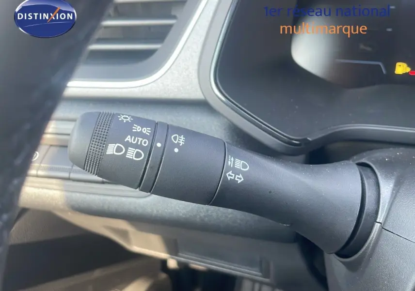 Gros plan sur la commande des phares et clignotants du tableau de bord d'un Renault Captur bleu Iron Metal 2025.