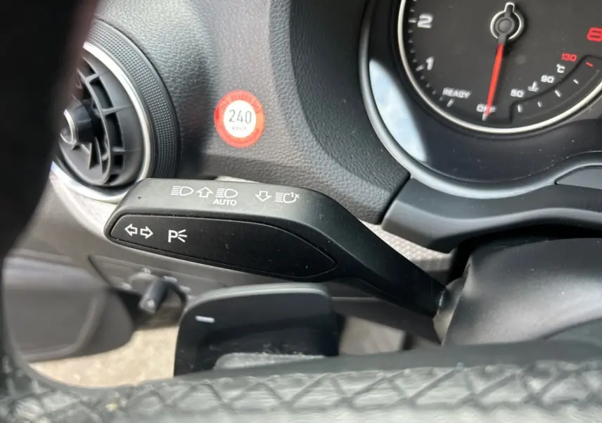 Gros plan sur le commodo gauche et le combiné d'instruments du tableau de bord noir de l'Audi Q2 35 TFSI 2023.