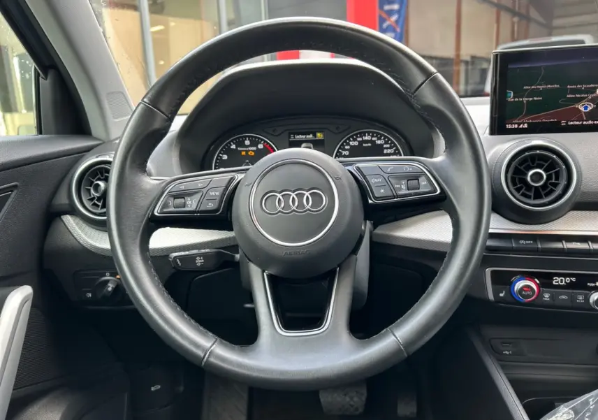 Volant cuir noir Audi Q2 35 TFSI 2023 vu de face, avec tableau de bord et écran tactile de navigation visible