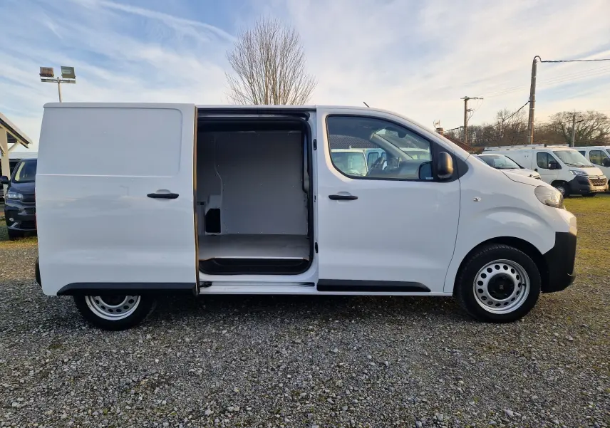 Vue de profil droit d’un FIAT Scudo Fourgon blanc 2024 avec porte coulissante ouverte montrant l’espace de chargement vide.