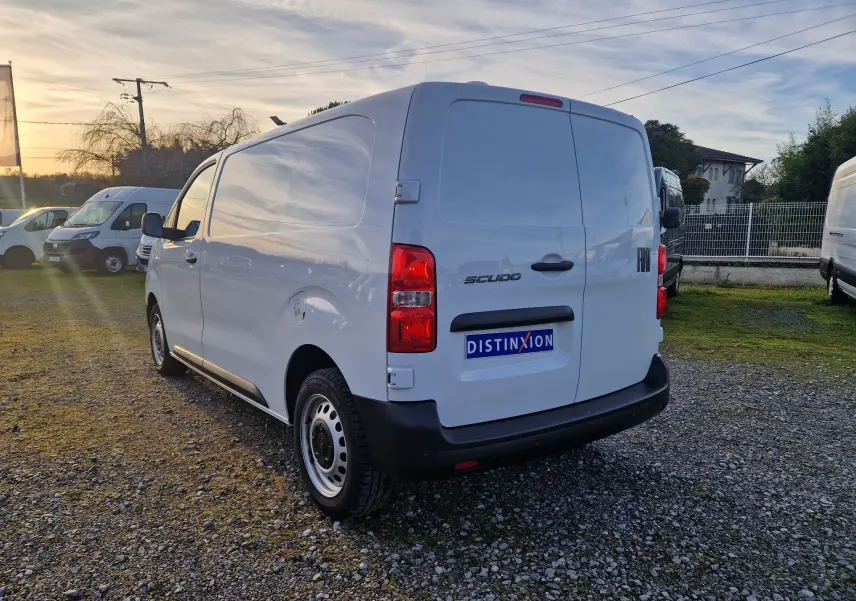 Vue 3/4 arrière droite d’un FIAT Scudo Fourgon blanc 2024 avec hayon fermé sur un parking extérieur.