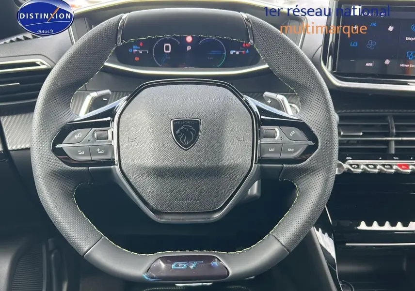 Vue centrée sur le volant cuir noir du Peugeot 2008 1.2 hybrid 145 GT avec tableau de bord numérique et écran tactile.