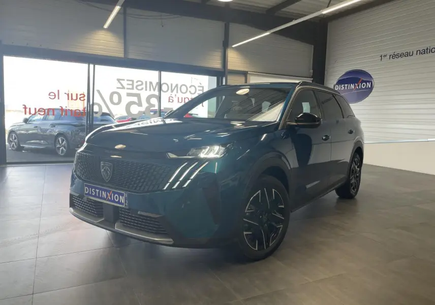 Peugeot 5008 Bleu Obsession en 3/4 avant droit, avec calandre noire et jantes alliage 19 pouces dans un showroom.