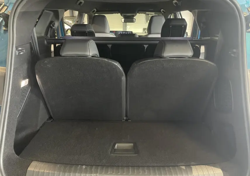 Vue arrière du coffre du Peugeot 5008 Bleu Obsession avec banquette 3e rangée relevée et intérieur noir.