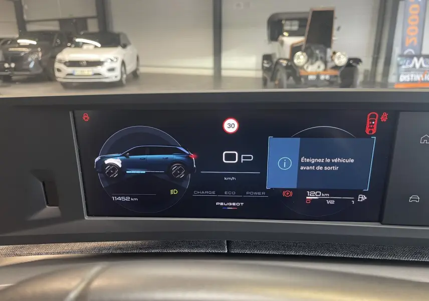 Écran numérique du tableau de bord du Peugeot 5008 Bleu Obsession affichant la silhouette du véhicule et alertes de sécurité.