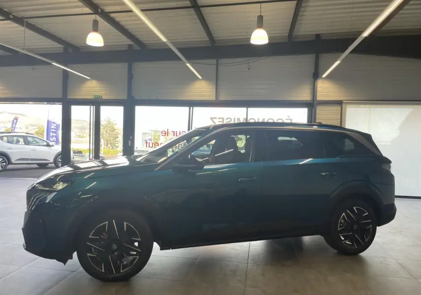 Peugeot 5008 Bleu Obsession vue de profil côté gauche en intérieur avec jantes alliage noires et toit noir.