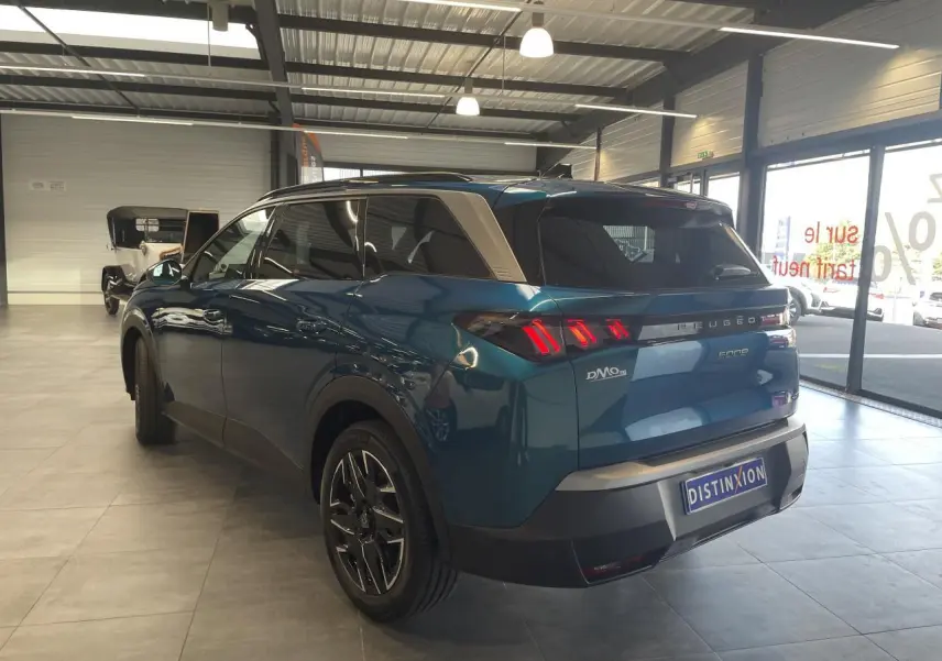 Vue 3/4 arrière droite du Peugeot 5008 bleu Obsession avec feux arrière LED en forme de griffes et jantes alliage 19 pouces.